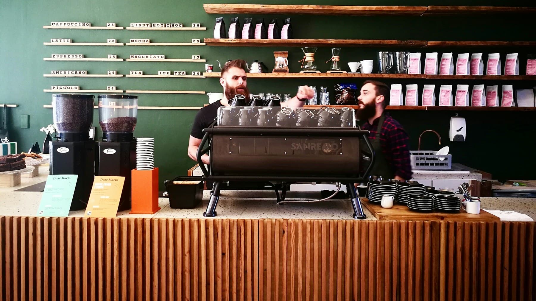 Two baristas working behind the counter of an independent coffee shop